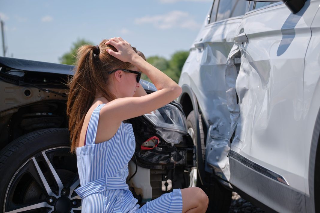 Ilustracija prometne nezgode, sudar dvaju automobila i žena koja se drži za glavu