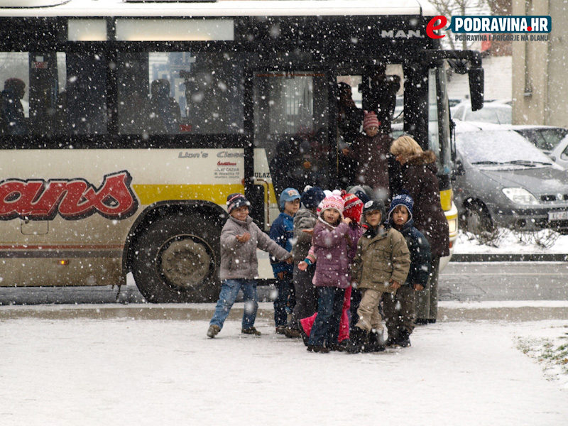 Djeca izlaze iz autobusa i pada snijeg