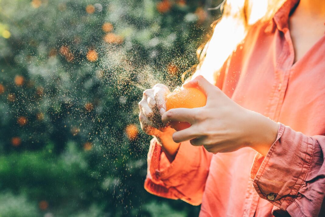 Žena guli sočnu naranču